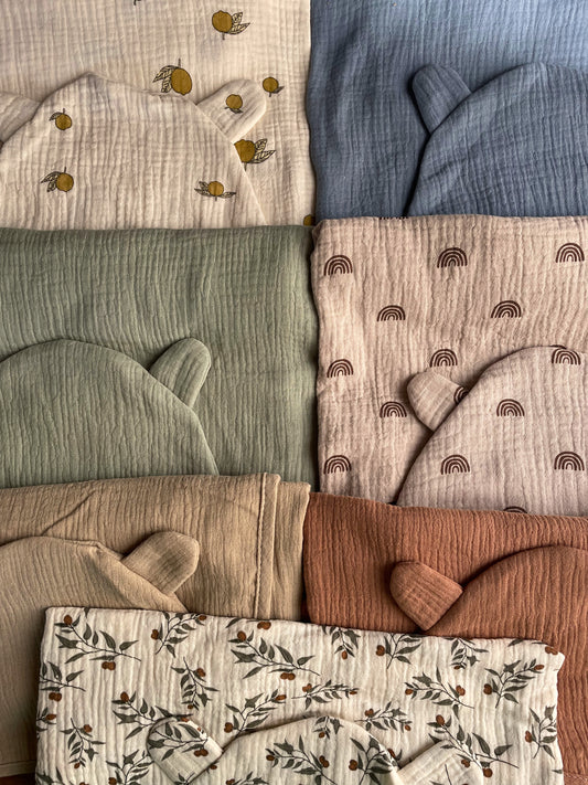 seven hooded bath towels are folded neatly and laid next to each other