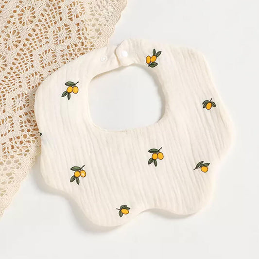 a drool bib with a yuzu design lies next to a crochet mat